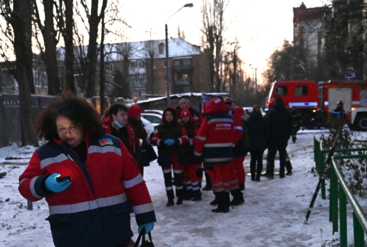 Rescuer workers gather at near the impact site of a downed Russian attack drone