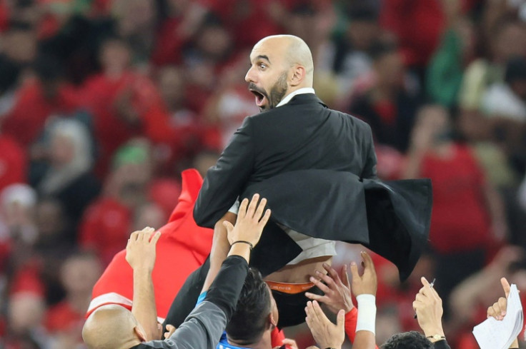 Morocco's players lift aloft coach Walid Regragui after their win against Portugal in the World Cup quarter-finals