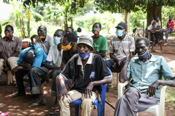 Residents of Lukodi, a village where dozens were killed by the Lord's Resistance Army in 2004, listen to the ICC hand down its sentence against Ongwen in 2011