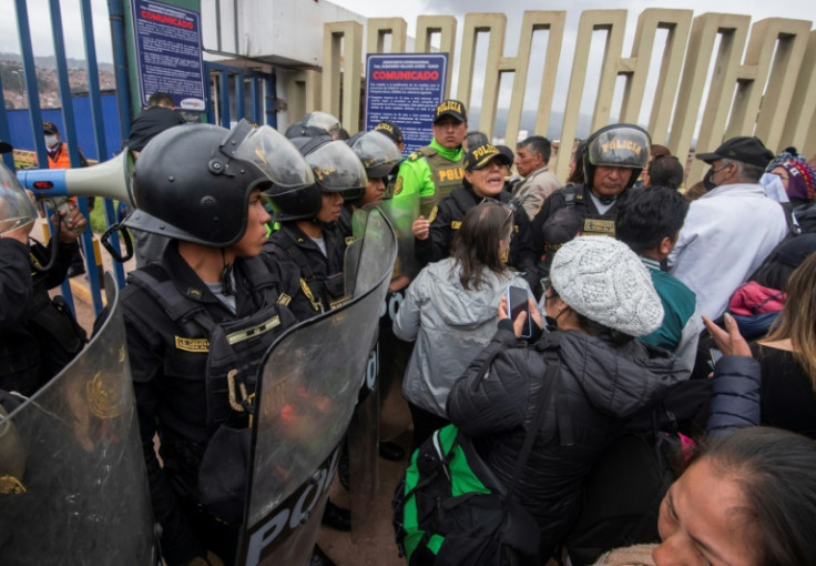Peruvian police guard the entrance to Cusco airport after it was closed due to protests, stranding tourists in the Machu Picchu region