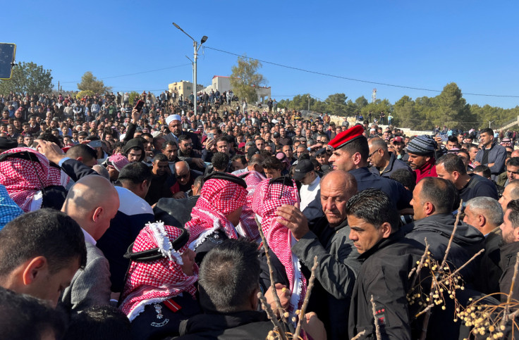 People gather during the funeral of senior police officer who was killed in riots on Thursday night according to authorities