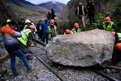 Workers attempt to remove a rock protesters had pushed from a cliff on to the track from the Inca citadel of Machu Picchu