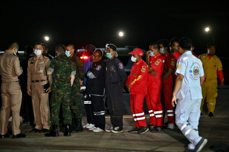 Thai army personnel and rescue crew gather at a makeshift rescue operation site during the search for survivors after the capsizing of the Thai naval vessel HTMS Sukhothai