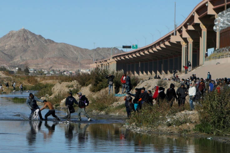 Migrants walk across the Rio Grande to surrender to US Border Patrol agents in El Paso, Texas, as seen from Ciudad Juarez, Mexico
