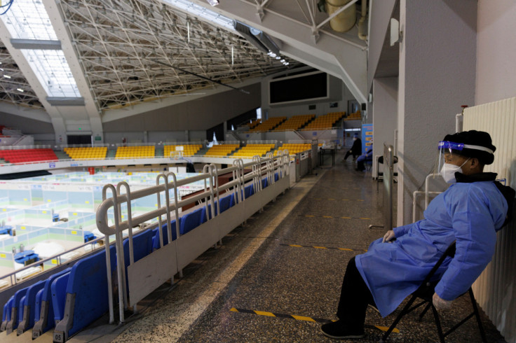 A security guard keeps watch in a makeshift fever clinic that was set up in a sports area as COVID-19 outbreaks continue in Beijing