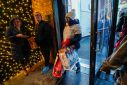 People carrying shopping bags exit a retail store during the holiday season in New York