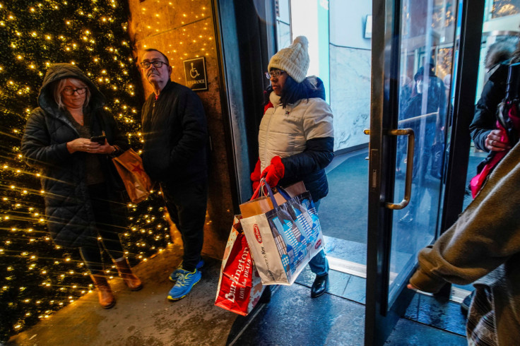 People carrying shopping bags exit a retail store during the holiday season in New York