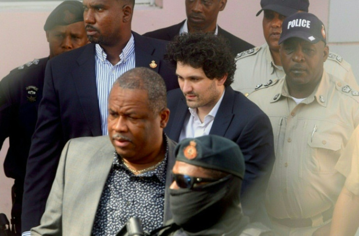 FTX founder Sam Bankman-Fried (C) handcuffed and escorted by law enforcement at a Nassau, Bahamas court