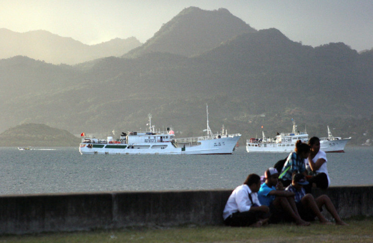 Locals sit on a wall at the harbour in the Fiji capital of Suva