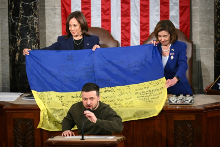 House Speaker Nancy Pelosi, left, and Vice President Kamala Harris hold a Ukrainian battle flag donated to Congress by Zelensky, front