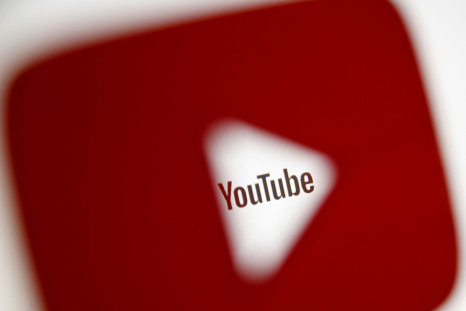 A 3D-printed YouTube icon is seen in front of a displayed YouTube logo in this illustration