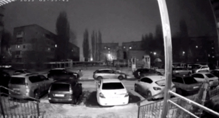 A surveillance camera shows how vehicles are illuminated by a flash of light from an explosion,in Engels