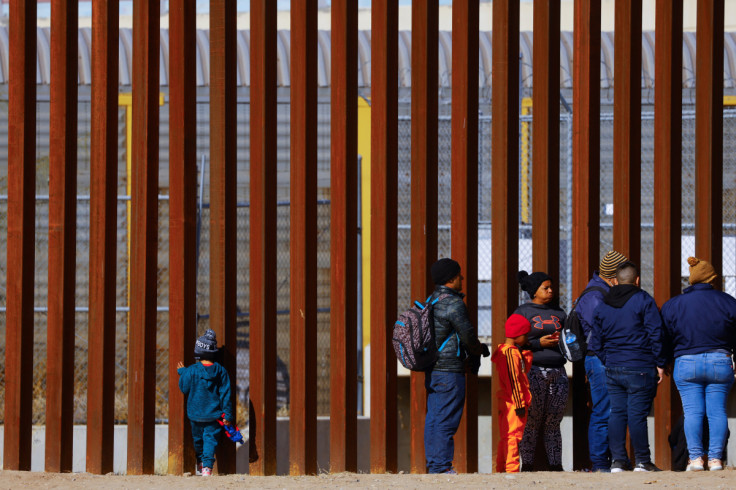 George, 5, a migrant boy from Venezuela traveling with his family, looks through the border wall as they queue to request asylum in El Paso, Texas, United States, seen from Ciudad Juarez