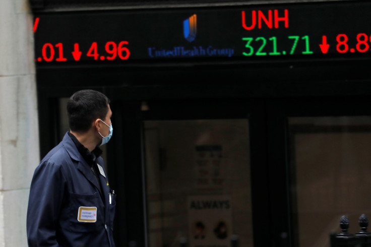 A trader walks past a digital stock price display outside the New York Stock Exchange in New York