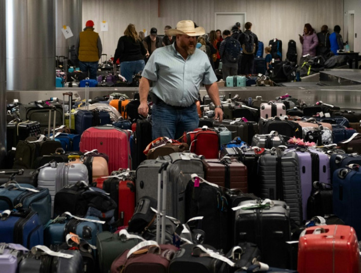 A passenger searches through hundreds of unclaimed suitcases near the Southwest Airlines baggage claim area at Nashville International Airport after the airline canceled thousands of flights