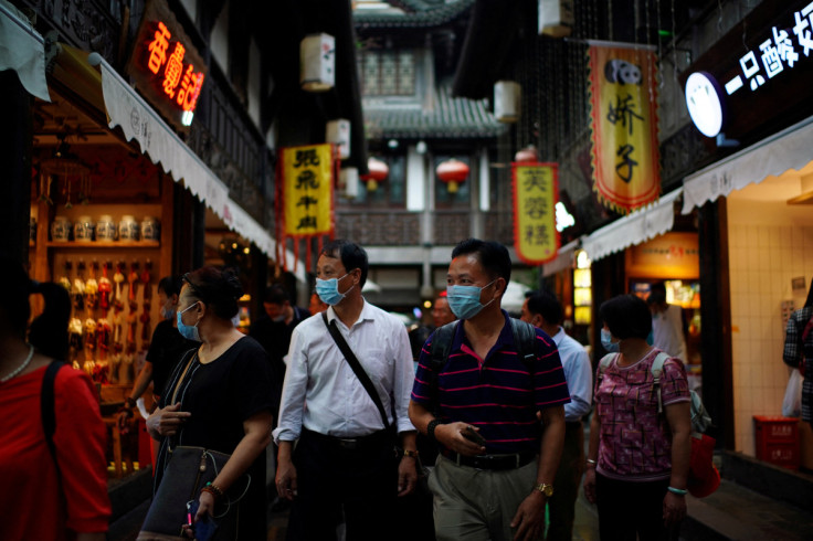 People wearing face masks walk on Jinli Ancient Street in Chengdu