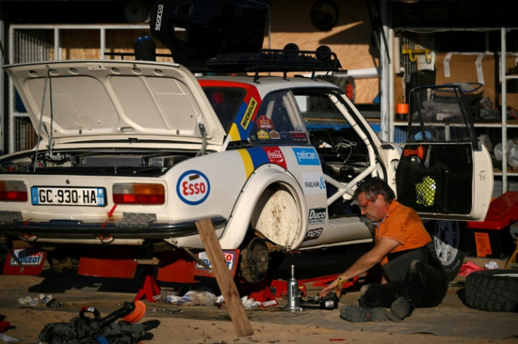 A competitor makes some late alterations to his car ahead of the Dakar Rally