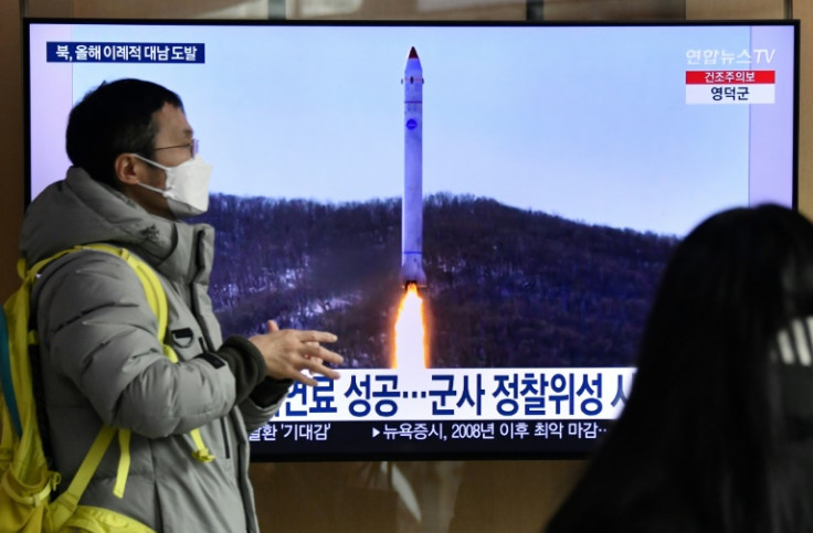 A man walks past a television screen showing a news broadcast with file footage of a North Korean missile test, at a railway station in Seoul on December 31, 2022 after North Korea fired three short-range ballistic missiles according to South Korea's mili