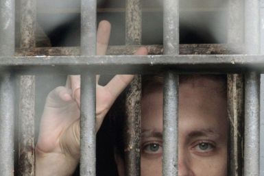 A Belarussian detainee, arrested during the flash mob &quot;Revolution through a social network&quot;, flashes a victory sign