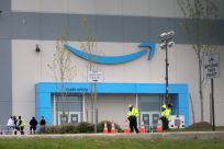 Security personnel are seen as Amazon workers gather outside Amazon’s LDJ5 sortation center in Staten Island, New York