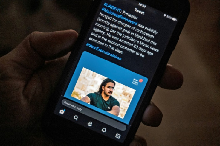 A person in the Cypriot capital Nicosia checks a mobile phone displaying a tweet about the execution of Majidreza Rahnavard