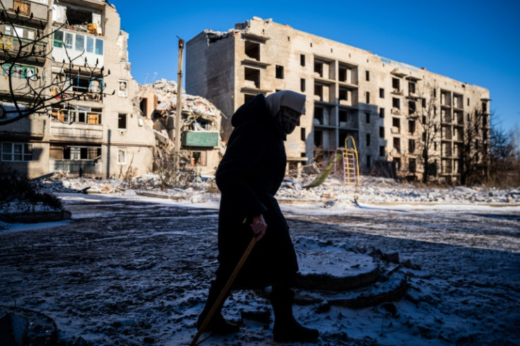 An elderly local resident walks past a destroyed residential building in Chasiv Yar, Eastern Ukraine