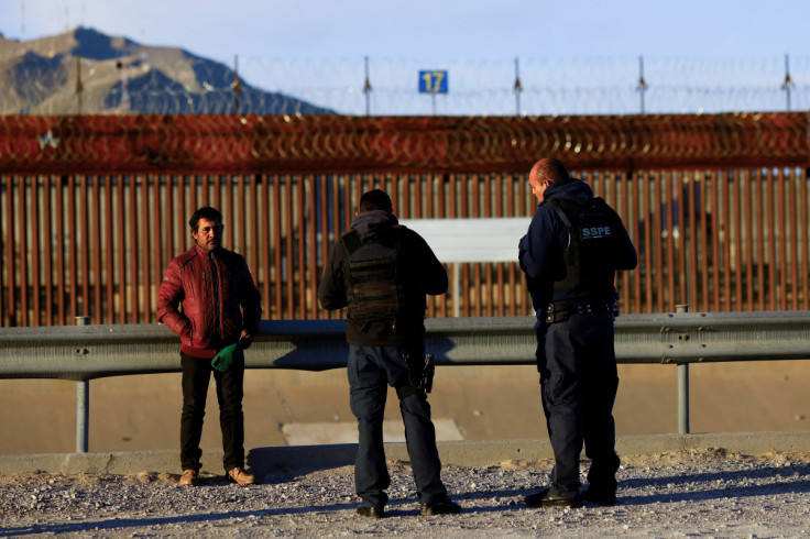 Mexican police officers question Erlan Garay, a migrant from Honduras trying to reach the United States, near the border between the United States and Mexico, in Ciudad Juarez