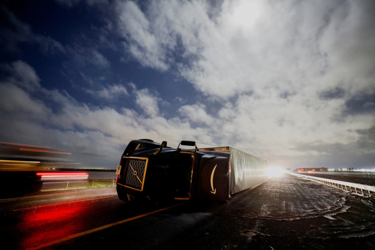 A semi tractor-trailer lies on its side along after it was toppled by high winds during a winter storm along Interstate 5 in Woodland