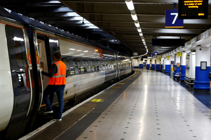 A worker stands at the door of a train at Euston station as rail workers continue a strike over pay and terms, in London