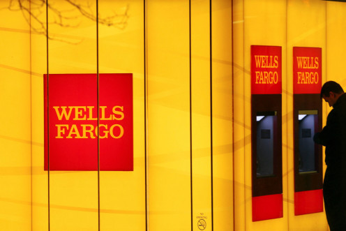 A man uses an automated teller machine (ATM) at a Wells Fargo Bank branch on a rainy morning in Washington