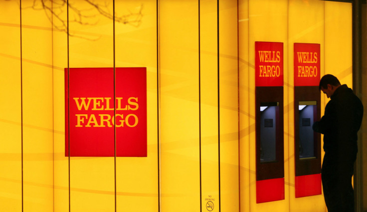 A man uses an automated teller machine (ATM) at a Wells Fargo Bank branch on a rainy morning in Washington