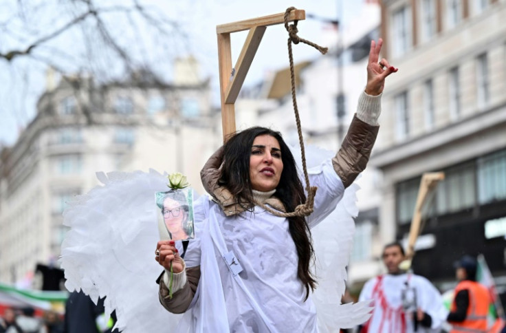 Protesters pose in mock gallows as they gather in central London on January 8, 2023 for a march against the Iranian regime