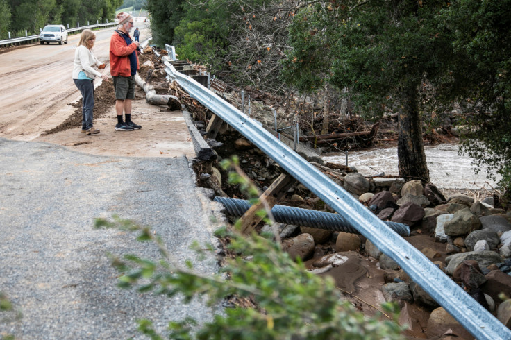 People view damage to a roadway after flooding on Highway 150 near Ojai