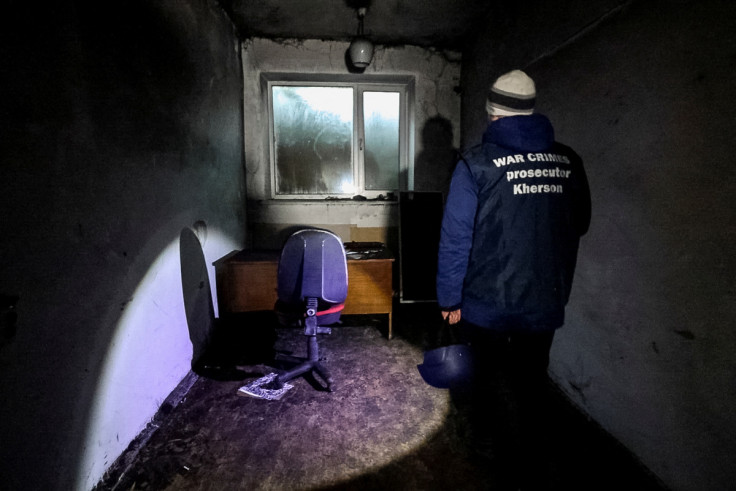 A war crime prosecutor inspects a basement of an office building, where prosecutor's office says 30 people were held for two months during the Russian occupation, in Kherson
