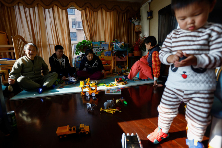 Tang Huajun, Ang Ran and her parents sit near their 2-year-old son Tang Ziang at their home in Beijing