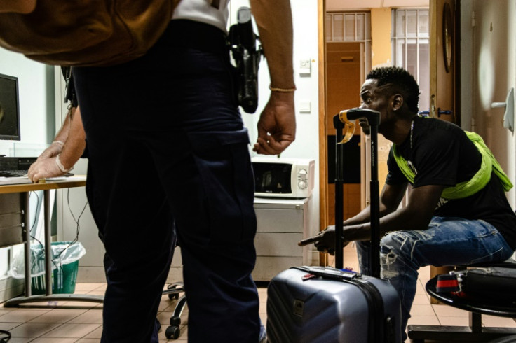 Border force police search a passenger boarding a flight from Cayenne, French Guiana