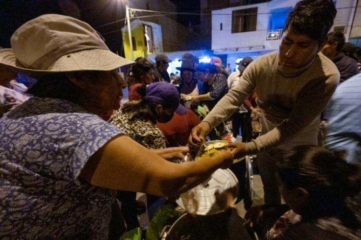 Women members of the Chanka indigenous community distribute food to demonstrators on their journey from Peru's south to the capital Lima