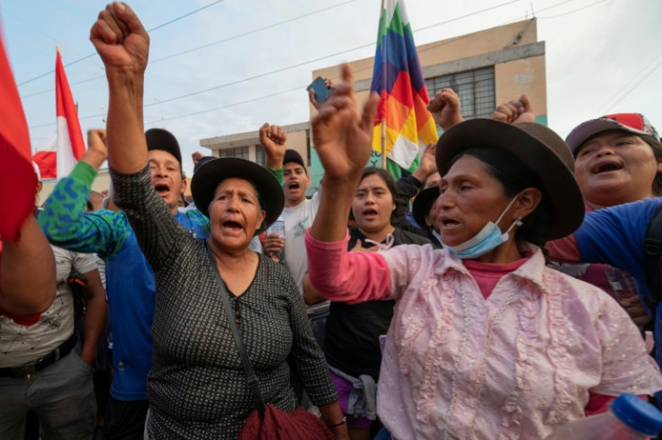 Peruvian demonstrators brandish indigenous flags as they protest against the government of President Dina Boluarte