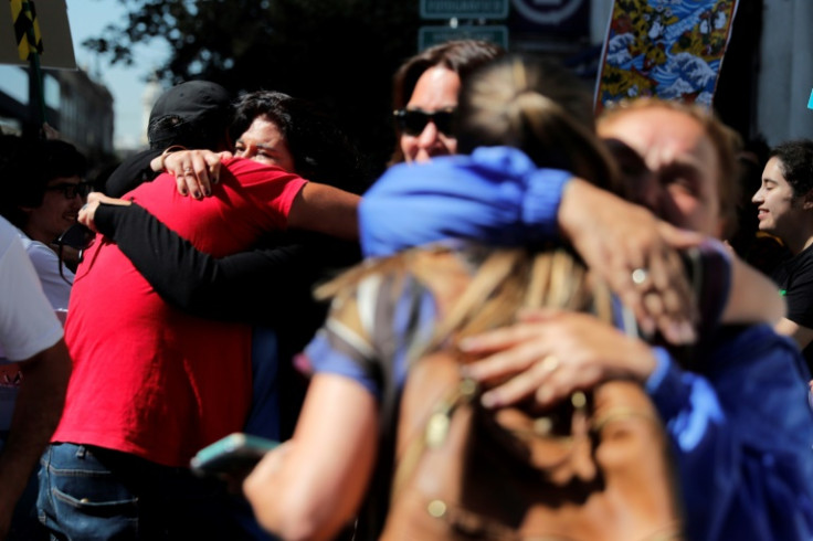 Protesters hug after learning of the Chilean government decision to reject the Dominga mine and port project