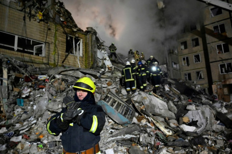 Rescuers search for survivors and victims in the rubble of a residential vuilding after a missile strike, in Dnipro