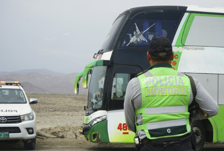 A police officer keeps watch on a bus carrying protesters in Nazca, Peru, on January 17, 2023