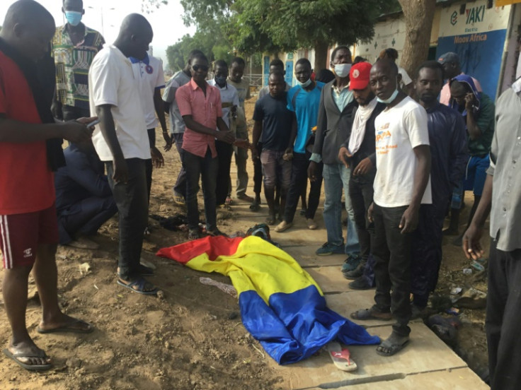 A body lies covered with the Chadian flag during the clashes that broke out in N’Djamena on October 20