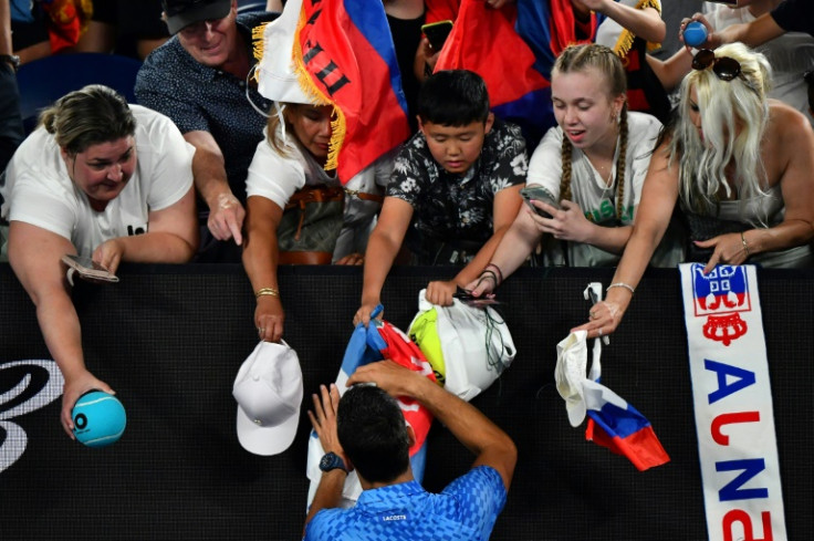 Serbia's Novak Djokovic signs autographs after winning against Spain's Roberto Carballes Baena