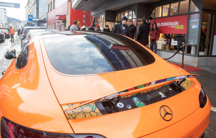 Bitcoin stickers are seen under the spoiler of a sports car standing in front of the Blockchain Hub Davos 2023 in Davos
