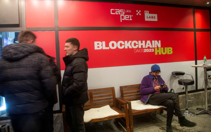 Orang-orang berdiri di depan Blockchain Hub Davos 2023 selama World Economic Forum di Davos