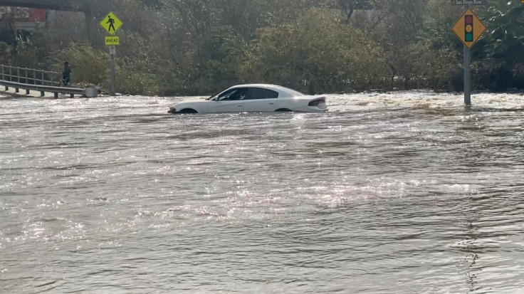 A car is stranded in a flooded street in San Diego