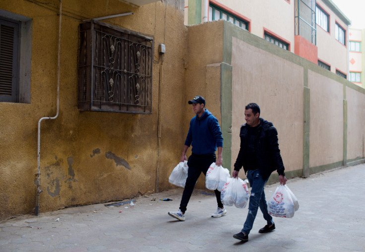 Team members of Abwab El Kheir Foundation charity carry bags of food and donations from their office in Cairo