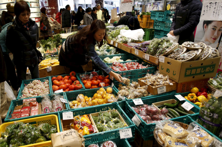 A shopper looks at packs of vegetables at a market at a shopping district in Tokyo