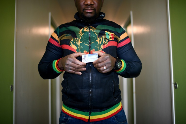 https://d.ibtimes.com/en/full/4408773/undocumented-worker-mali-holding-his-access-card-olympic-construction-site-where-he-worked.jpg