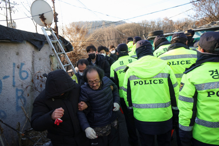 Residents receive help near the site of a fire at Guryong village, the last slum in the glitzy Gangnam district, in Seoul